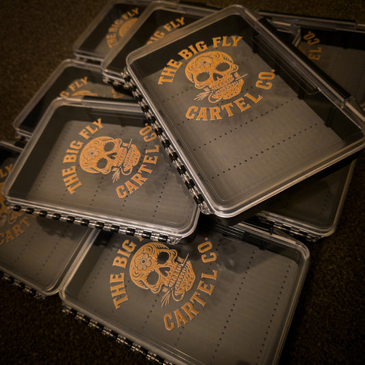 Stack of 'The Big Fly Cartel Co' branded trays on a dark background